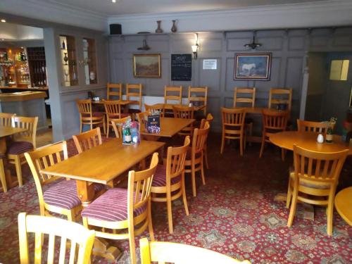 a dining room with wooden tables and chairs at The Wellington Hotel in Howden