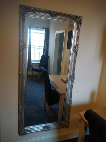 a mirror in a room with a desk and a chair at The Wellington Hotel in Howden
