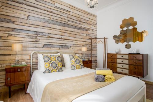 a bedroom with a bed with a wooden wall at Sunny Apartment in a typical Lisbon neighborhood in Lisbon