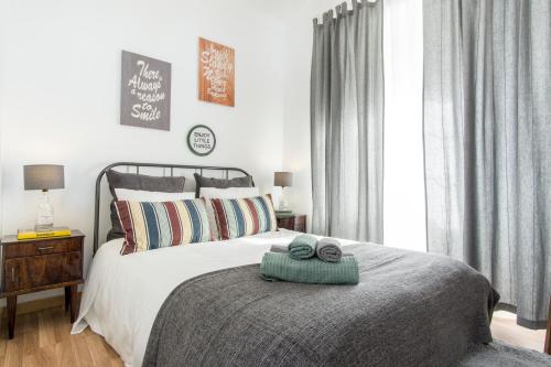 a bedroom with a bed with two towels on it at Sunny Apartment in a typical Lisbon neighborhood in Lisbon