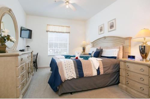 a bedroom with a bed and a dresser and a mirror at DREAM Vacation BY A3G in Orlando