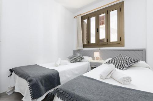 1 dormitorio con 2 camas y ventana en Alcudia Apartments, en Puerto de Alcudia