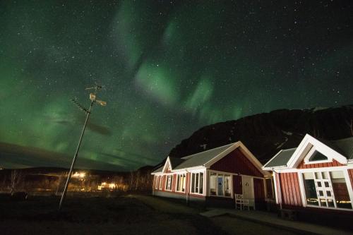 an image of the aurora in the sky over houses at Kría Cottages in Skeljabrekka