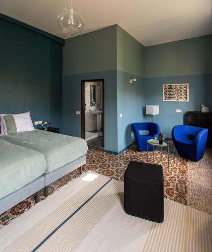 a bedroom with blue walls and a bed and blue chairs at Villa Nestor in Ingenio