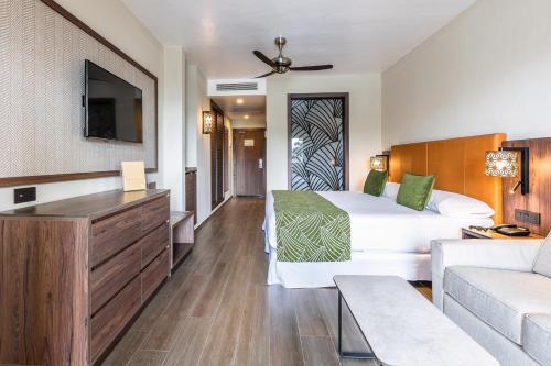 a hotel room with a bed and a couch at Riu Palace Zanzibar - All Inclusive in Nungwi