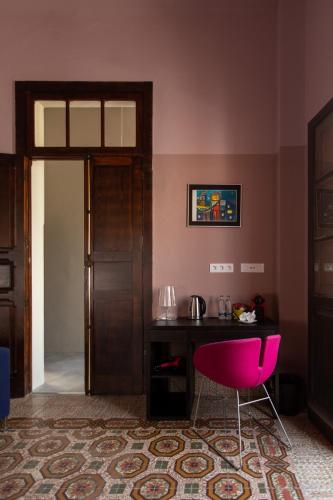 a pink room with a table and a pink chair at Villa Nestor in Ingenio