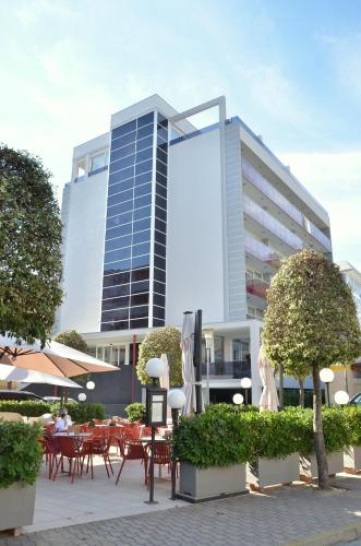 a building with tables and chairs in front of it at Hotel Amburgo in Bibione