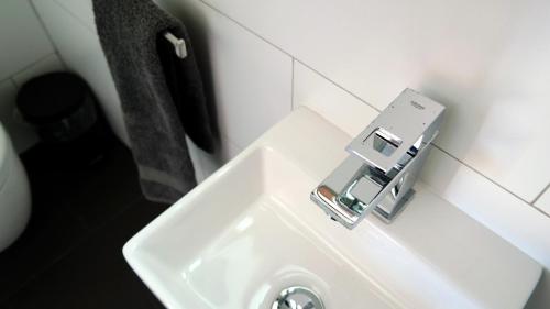 a white bathroom sink with a silver faucet at Panorama Indlu in Cape Town