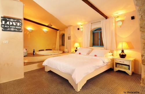 a bedroom with a large bed and a bath tub at THE MANSION in yesod hamaala in Yesod Hamaala