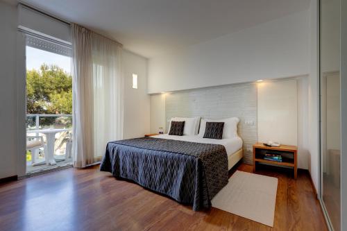 Tempat tidur dalam kamar di Park Hotel Ermitage Resort & Spa