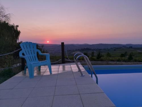 - deux chaises assises à côté d'une piscine au coucher du soleil dans l'établissement Villa Gaia, à Santa Maria della Versa