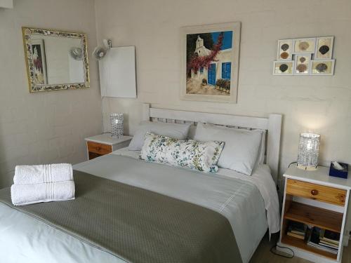 a small bedroom with a bed and two night stands at Langebaan Paradise Beach 9 Elara in Langebaan
