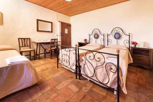1 dormitorio con 2 camas, mesa y sillas en Agriturismo Girolomoni - Locanda en Isola del Piano