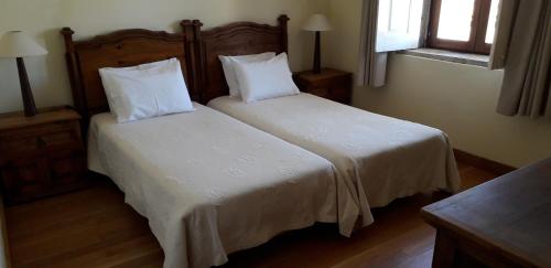 1 dormitorio con 2 camas con sábanas y almohadas blancas en Casa dos Pombais de Caçarelhos Rural en Caçarelhos