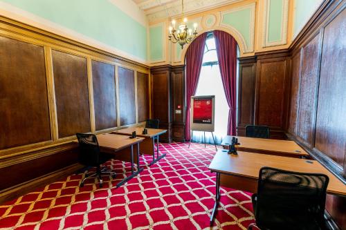 a room with wooden tables and a red carpet at Adelphi Hotel in Liverpool