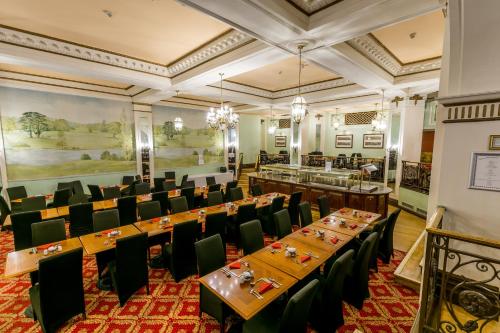 a dining room with tables and chairs and a painting at Adelphi Hotel in Liverpool
