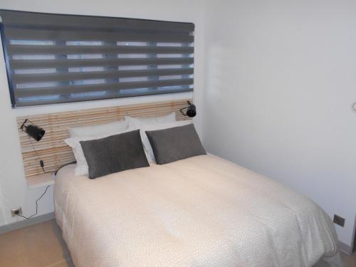a bedroom with a white bed with two pillows at 4MIN ORLEANS APPT 1CHB PLEIN AU CALME AVEC TERRASSE ET PARKING DEVANT in Saint-Jean-de-Braye