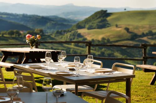 a table with wine glasses on it with a view at Agriturismo Girolomoni - Locanda in Isola del Piano