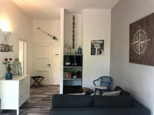 a living room with a blue couch and a chair at Le Lanterne Resort in Pantelleria