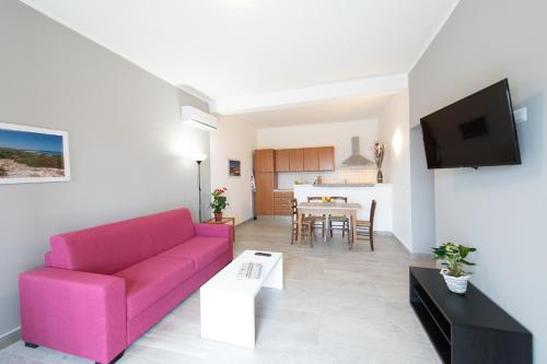 a living room with a pink couch and a table at "Il Segreto" Vista Panoramica sulle Isole Eolie con Piscina, palestra e WiFi in Patti