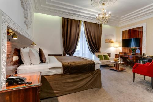 莫斯科的住宿－三朵尼切斯卡婭市中心酒店，酒店客房设有一张大床和一张书桌。