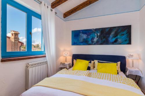 Un dormitorio con una cama con almohadas amarillas y una ventana en Villa-Johanna, en Kaštelir