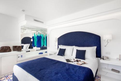 a bedroom with a blue and white bed with a blue headboard at Hotel Antiche Mura in Sorrento
