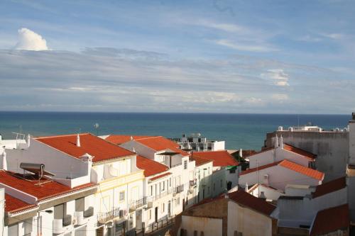 un grupo de edificios con el océano en el fondo en Casa Do Canto, en Albufeira