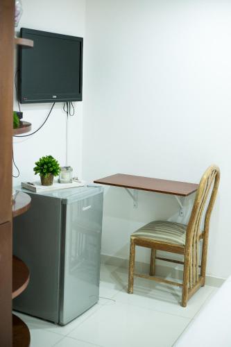 a desk with a chair and a desk with a television at Beulah Hotel Boutique in Asuncion