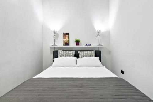 - une chambre blanche avec un lit et deux oreillers dans l'établissement MStudio / Loft, à Lecce