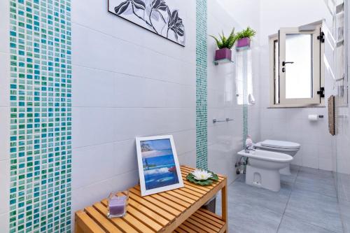 La salle de bains est pourvue de toilettes et d'une photo sur une table. dans l'établissement MStudio / Loft, à Lecce