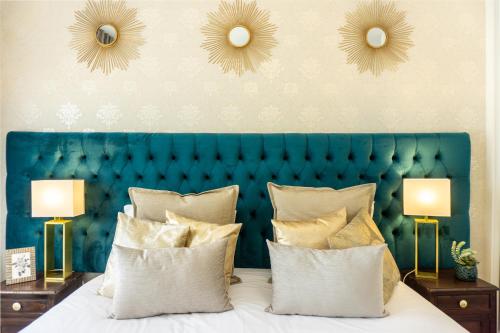 a bed with a blue head board and two lamps at Gaze out at the City in a Retro-Chic Getaway in Lisbon