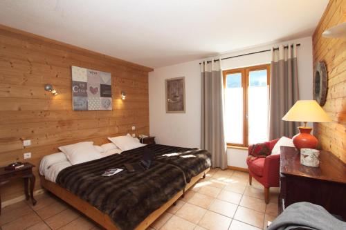 a hotel room with a bed and a red chair at Panoramic Village - Locations vue Glaciers - Chez Philippe in La Grave