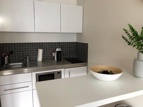 a white kitchen with a sink and a microwave at Saarland Appartements in Wadgassen