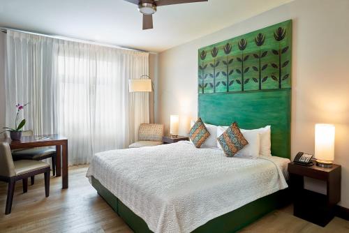 1 dormitorio con 1 cama y una pintura verde en la pared en R Hotel Kingston en Kingston