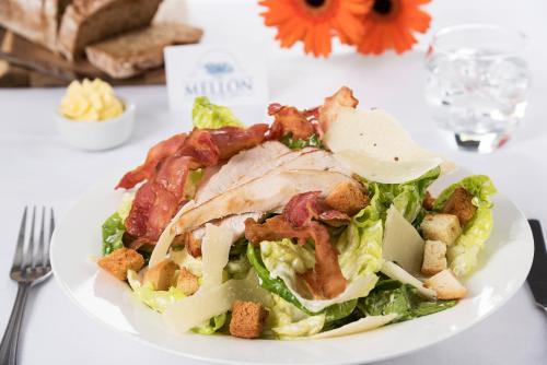 a white plate with a salad with meat and bacon at Mellon Country Inn Hotel in Omagh