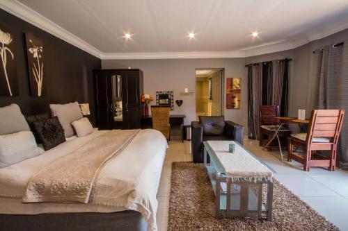 a bedroom with a large bed and a living room at New Bali Guesthouse in Newcastle