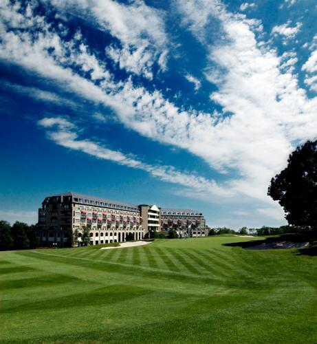 un gran edificio con un campo verde delante de él en The Celtic Manor Resort, en Newport