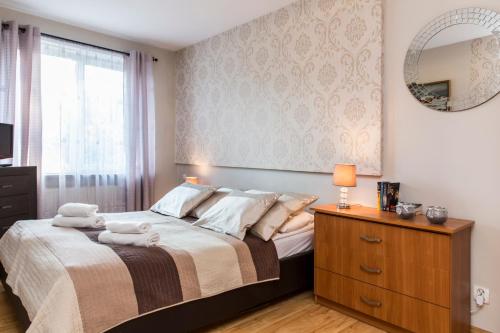 een slaapkamer met een bed met een spiegel en een dressoir bij Na Stromej in Zakopane