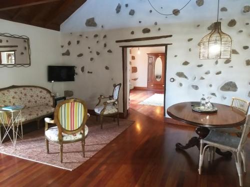 - un salon avec un canapé, une table et des chaises dans l'établissement Rural Rugama, à Puerto del Rosario