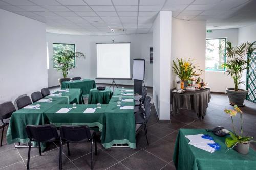 a conference room with green tables and chairs and a whiteboard at Best Western Park Hotel Roma Nord in Fiano Romano