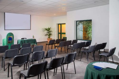 a room with chairs and tables and a white wall at Best Western Park Hotel Roma Nord in Fiano Romano