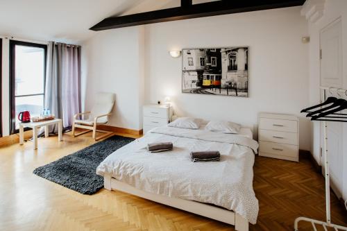 a bedroom with a large white bed and a desk at Green Wood Apartament Stara Ochota in Warsaw