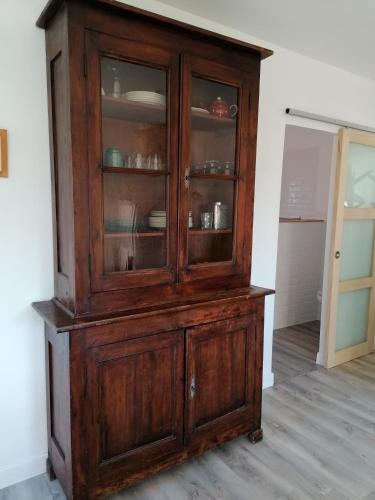 une armoire en bois avec des portes vitrées dans une pièce dans l'établissement Le Grenier de Gaston, à Thouars-sur-Garonne
