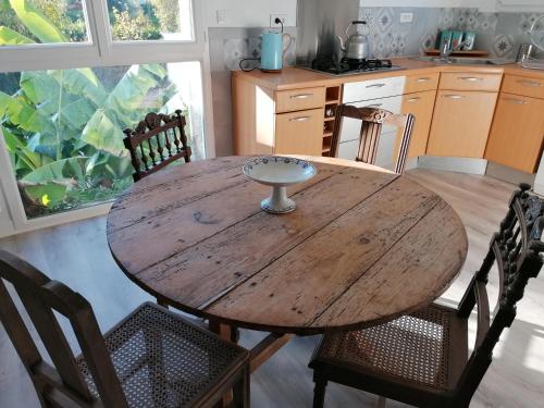 a wooden table and chairs in a kitchen at Le Grenier de Gaston in Thouars-sur-Garonne