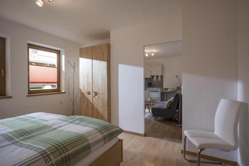 ein Schlafzimmer mit einem Bett und einem Stuhl darin in der Unterkunft Ferienwohnung Ager-Bucher in Ellmau