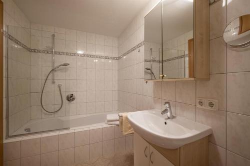 y baño blanco con lavabo y ducha. en Ferienwohnung Ager-Bucher en Ellmau