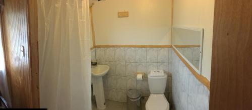 uma pequena casa de banho com WC e lavatório em Puesto Cánogas Hostal em Villa O'Higgins