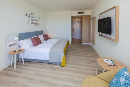 Habitación de hotel con cama grande y sofá en Abora Interclub Atlantic by Lopesan Hotels, en San Agustín
