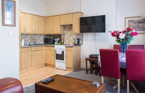 una cocina y comedor con una mesa con un jarrón de flores en Town Centre Apartment en Leamington Spa